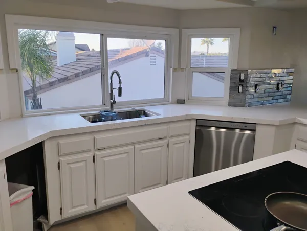 AJM Construction Services project: finished kitchen remodel with quartz countertops, stainless dishwasher and stone backsplash
