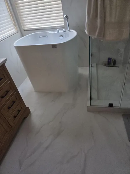 AJM Construction Services project: bathroom remodel with deep soaking tub, glass shower and marble-look tile floor