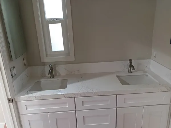AJM Construction Services project: white shaker double vanity with quartz countertop and undermount sinks