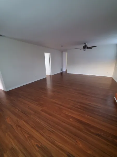 AJM Construction Services project: living room with new wood-look flooring and fresh paint